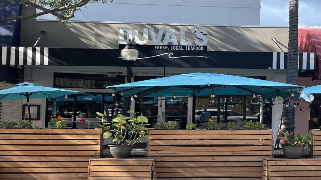 blue patio umbrellas and patio area with wooden planter boxes.