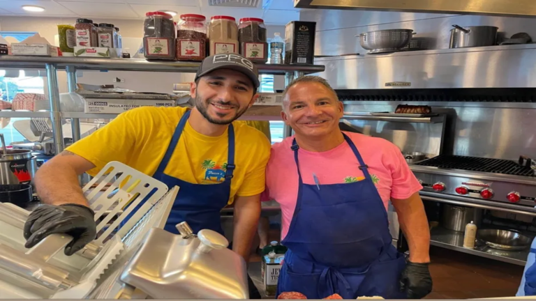 two men in blue aprons in kitchen