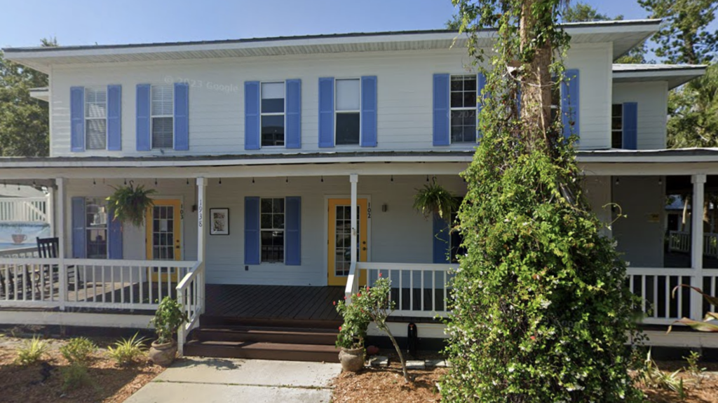 building on street with trees and porch