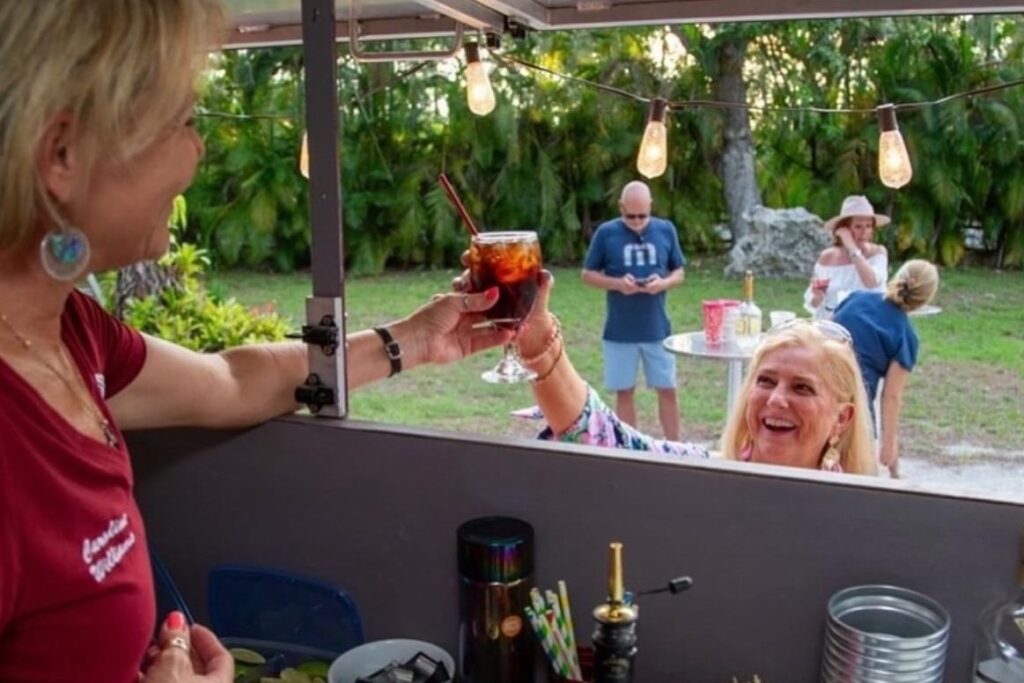 woman handing a drink to another woman.