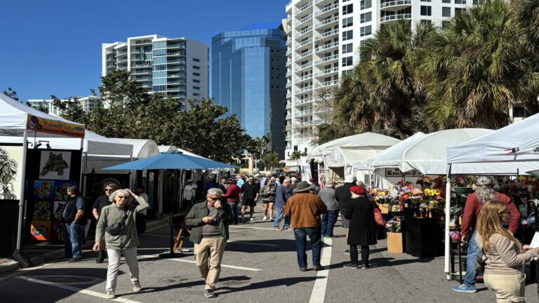 tents in a parking lot and with large buildings in the background