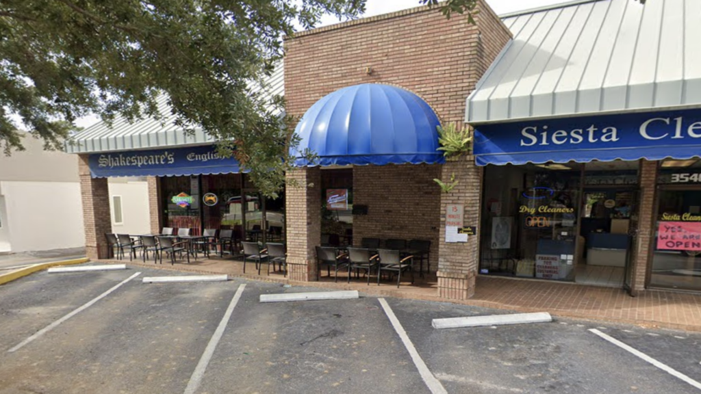 brick building with three empty parking spaces in front of it.